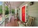 Covered front porch featuring classic rocking chairs and a striking red front door at 5876 Bridgemont Nw Pl, Acworth, GA 30101