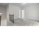 Upstairs hallway with neutral walls and carpet leading to doorways and featuring a wood and iron railing at 529 Lanier Way, Temple, GA 30179