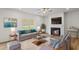 Bright living room with fireplace, ceiling fan, hardwood floors, and large window at 529 Lanier Way, Temple, GA 30179