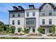 Striking townhome exteriors with a mix of brick, siding, dark trim, and dormer windows under a bright blue sky at 529 Rubato Knl, Mcdonough, GA 30253