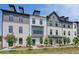 Contemporary townhome exteriors featuring white brick, dark gray trim, and dormer windows for added architectural detail at 529 Rubato Knl, Mcdonough, GA 30253