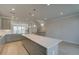 Large kitchen island with gray cabinets, quartz countertops and pendant lighting at 529 Rubato Knl, Mcdonough, GA 30253
