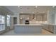 Modern kitchen with stainless appliances, gray cabinets, large island, and pendant lighting at 529 Rubato Knl, Mcdonough, GA 30253