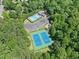 Aerial view of a community pool and tennis courts surrounded by lush trees and greenery at 614 Springharbor Dr, Woodstock, GA 30188