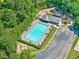 Aerial view of a community pool, deck chairs, and umbrellas surrounded by lush greenery at 614 Springharbor Dr, Woodstock, GA 30188