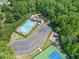 Aerial view of a community pool, tennis courts, and playground area surrounded by trees at 614 Springharbor Dr, Woodstock, GA 30188