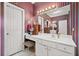 Bathroom with vanity and sink, large mirror, white cabinets, and striped wallpaper at 614 Springharbor Dr, Woodstock, GA 30188