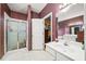 Bathroom showcasing a shower and dual vanities with framed mirrors and striped wallpaper at 614 Springharbor Dr, Woodstock, GA 30188