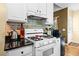 Cozy kitchen featuring white cabinets, granite counters and a white stove at 614 Springharbor Dr, Woodstock, GA 30188