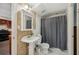 Traditional bathroom with patterned wallpaper, toilet, and shower with gray curtain at 7115 Doncaster Ct, Cumming, GA 30040