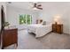 Sunlit bedroom features a ceiling fan, carpet, and a large window overlooking the yard at 7115 Doncaster Ct, Cumming, GA 30040