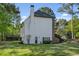 Side view of a brick and siding house with a green lawn and mature trees at 7115 Doncaster Ct, Cumming, GA 30040