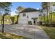 Home exterior with a driveway, basketball hoop, an attached garage, and mature trees at 7115 Doncaster Ct, Cumming, GA 30040