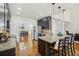 Open kitchen with granite counters, stainless appliances, hardwood floors, and island with bar seating at 7115 Doncaster Ct, Cumming, GA 30040