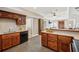 Open concept kitchen with wood cabinets, tile floors, and a view into the living area at 7115 Doncaster Ct, Cumming, GA 30040