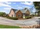 Charming stone and siding home with manicured landscaping, circular drive, and screened porch at 1304 Brookhavenrun Cir, Duluth, GA 30097