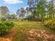 Large, grassy backyard with mature trees and a wooden fence at 1307 Chandler Nw Ct, Acworth, GA 30102