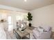 Open-concept living area features a comfortable seating arrangement, seamlessly connected to the kitchen and dining space at 2688 Ne Almand Ln, Conyers, GA 30013