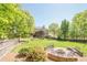 Large backyard featuring a stone fire pit with seating and a well-maintained lawn at 1010 Forest Creek Dr, Canton, GA 30115