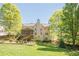 Expansive backyard with lush lawn, mature trees, and a screened porch at 1010 Forest Creek Dr, Canton, GA 30115