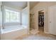 Primary bathroom showcasing a jetted tub, shower, and access to the walk in closet at 1010 Forest Creek Dr, Canton, GA 30115