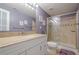 Clean bathroom featuring a tiled shower with glass door, granite countertop, and framed mirror at 1010 Forest Creek Dr, Canton, GA 30115