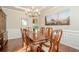 Elegant dining room with wood floors, chandelier, wainscoting and large table at 1010 Forest Creek Dr, Canton, GA 30115