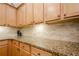 Close-up of granite countertops, wood cabinets, and tiled backsplash in a well-appointed kitchen at 1010 Forest Creek Dr, Canton, GA 30115
