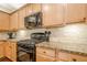 Gas range and granite countertops highlight this cozy kitchen with light wood cabinets and stainless appliances at 1010 Forest Creek Dr, Canton, GA 30115