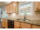 Kitchen sink and granite countertops complement the light wood cabinets and stone backsplash at 1010 Forest Creek Dr, Canton, GA 30115