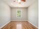 Bright bedroom featuring hardwood floors, a ceiling fan, and a window overlooking the backyard at 2914 Stanton Se Rd, Conyers, GA 30094
