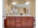Bathroom with double vanity, wood cabinets, bright lighting, and large mirror at 3448 Clear Stream Ne Run, Auburn, GA 30011