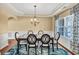 Elegant dining room with tray ceiling, chandelier, wainscoting, and large windows for natural light at 3448 Clear Stream Ne Run, Auburn, GA 30011