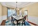 Formal dining room featuring wainscoting, modern chandelier, and a view of the entryway at 3448 Clear Stream Ne Run, Auburn, GA 30011