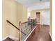 Second floor hallway with hardwood floors, a wood-railed staircase, and access to several rooms at 3448 Clear Stream Ne Run, Auburn, GA 30011