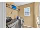 Efficient laundry room equipped with modern washer and dryer, plus convenient overhead shelving at 3448 Clear Stream Ne Run, Auburn, GA 30011