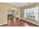 Comfortable living room with hardwood floors, a large window, and an archway leading to the dining room at 3448 Clear Stream Ne Run, Auburn, GA 30011