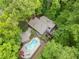 Aerial view of a home with mature trees, a pool and a long driveway at 5276 Weatherwood Trce, Marietta, GA 30068