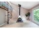 Bedroom features a spiral staircase, a fireplace, and a tree-filled view through an oversized window at 5276 Weatherwood Trce, Marietta, GA 30068