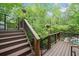 This property includes a composite deck with black metal railings and outdoor lighting surrounded by mature trees at 5276 Weatherwood Trce, Marietta, GA 30068