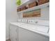 Bright laundry room with modern appliances, storage shelf and decor at 5276 Weatherwood Trce, Marietta, GA 30068
