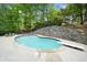 Enjoy this backyard pool with diving board and stone retaining wall landscaping at 5276 Weatherwood Trce, Marietta, GA 30068