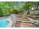 The sloped backyard includes a pool and stone steps at 5276 Weatherwood Trce, Marietta, GA 30068