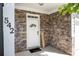 Inviting entrance with stone facade, 'Welcome' sign, and well-decorated door with a black 'hello' door mat at 542 Broughton Dr, Canton, GA 30114