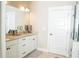 Bright bathroom featuring double sink vanity with granite countertop and sleek white cabinets at 6340 Arlington Cir, Cumming, GA 30041