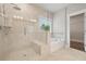 Bright bathroom with a glass-enclosed shower, soaking tub, and neutral tile at 6340 Arlington Cir, Cumming, GA 30041