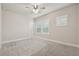 Bright bedroom with plush carpeting, a ceiling fan, and a large window at 6340 Arlington Cir, Cumming, GA 30041