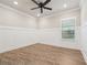 Spacious bedroom featuring hardwood floors, a ceiling fan, and stylish wainscoting at 6340 Arlington Cir, Cumming, GA 30041