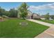 Beautifully landscaped front yard featuring a young tree, lush green grass, and welcoming curb appeal at 6340 Arlington Cir, Cumming, GA 30041