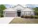 Traditional home featuring gray siding, a two-car garage, and manicured landscaping at 6340 Arlington Cir, Cumming, GA 30041